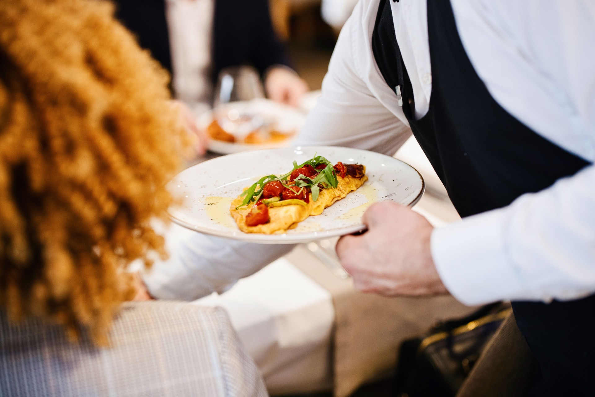 Garçom servindo café da manhã para os convidados